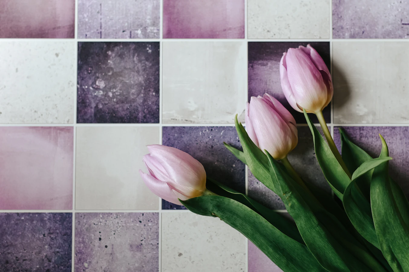 a topdown image of a set of white, purple and pink tiles with pink flowers on them